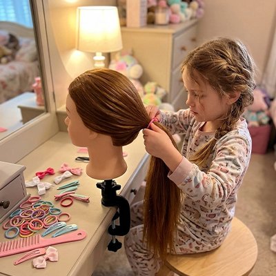 Enfant jouant avec une tête à coiffer